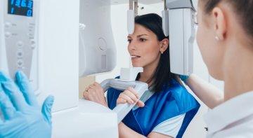 Teaserbild zeigt Frau in Röntgenapparat bei Zahnarzt